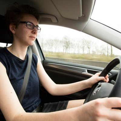 vrouw die gordel draagt achter het stuur