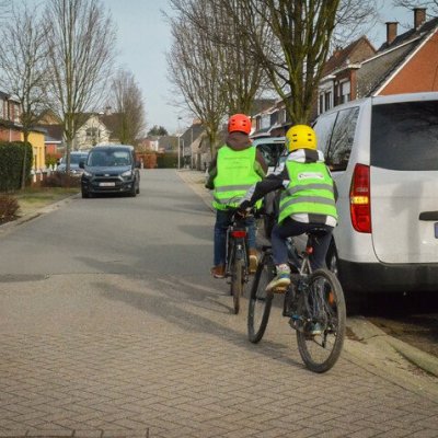 fietsers langs geparkeerde auto die wil vertrekken en pinkt