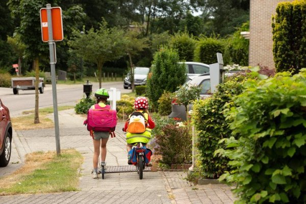 kinderen die op het fietspad fietsen en steppen