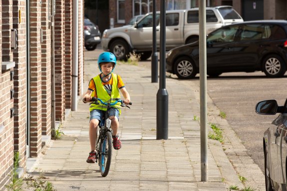 kind dat op het voetpad fietst