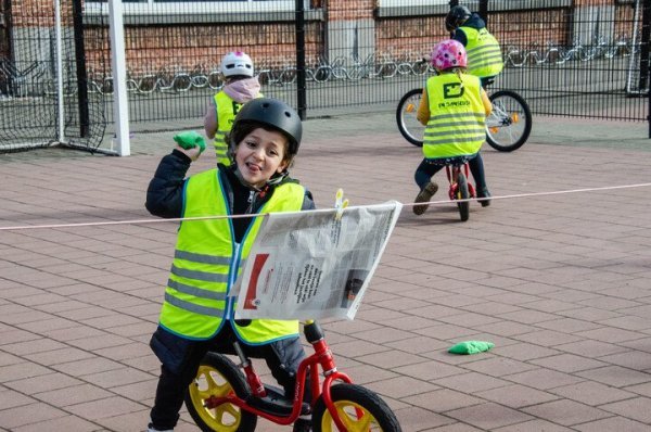 kinderen op loopfiets op speelplaats