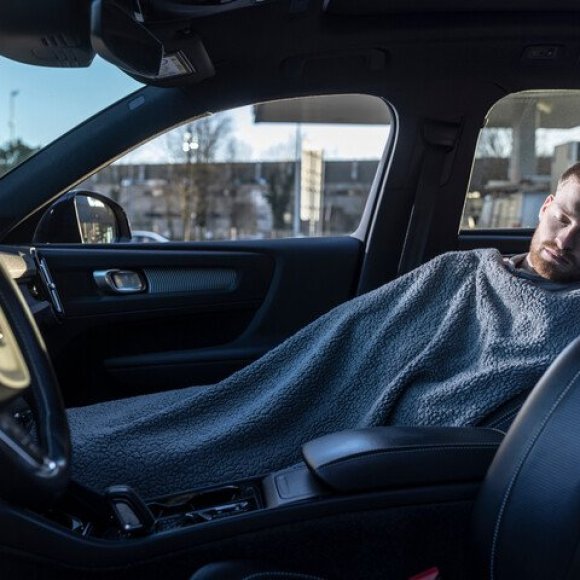 vrouw die powernap doet op achterbank van de auto