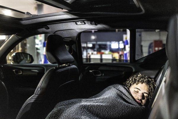 man die powernap doet op de achterbank van auto