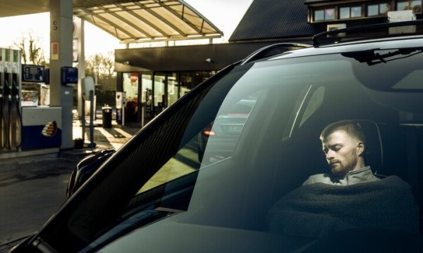 man die powernap doet in de auto, overdag