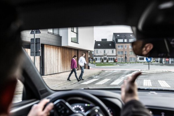 autobestuurder stopt aan zebrapad om voetgangers over te laten