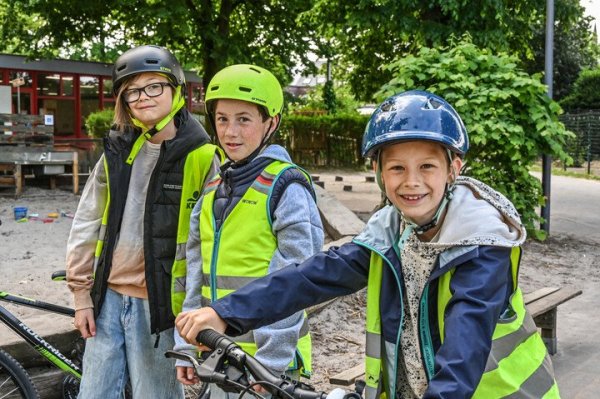 kinderen met fietshelm en fluohesjes