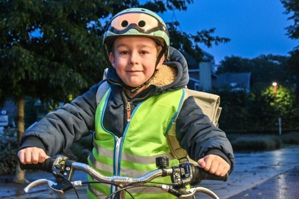 kind dat fietst in het donker met fluohesje