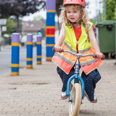 kind op een loopfiets dat balanceert