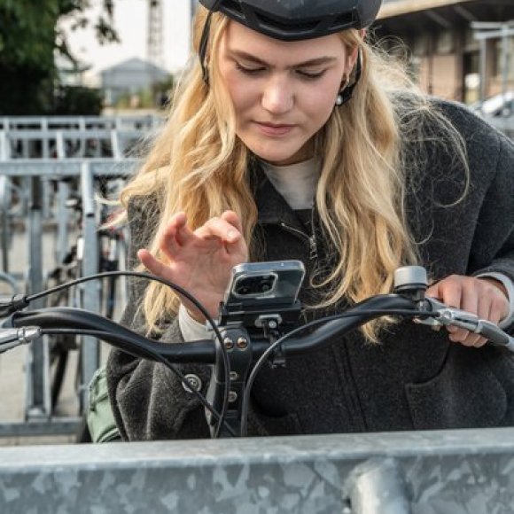 vrouw stelt fietsgps in op houder aan het stuur