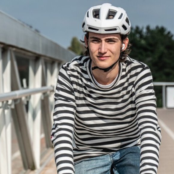 jongeman aan het fietsen met 1 oortje in