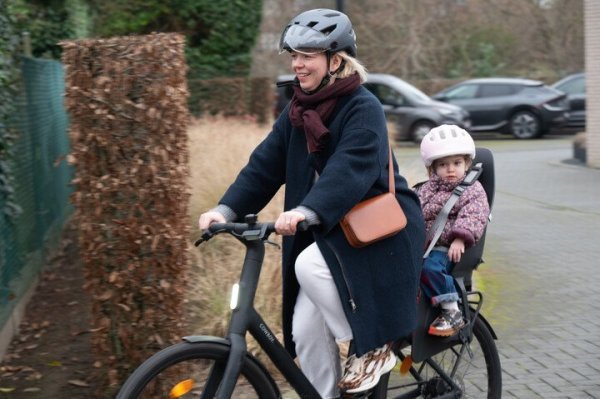 moeder die fietst met kind achteraan in fietsstoel