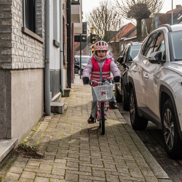 kind dat op het voetpad fietst