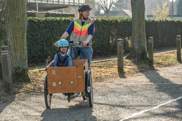vrouw die met bakfiets rijdt