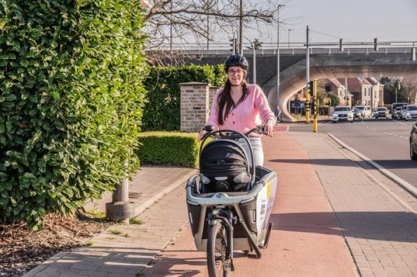 vrouw op bakfiets op een fietspad
