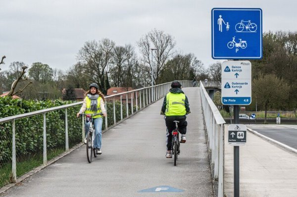 2 kruisende fietsers op een fietsbrug