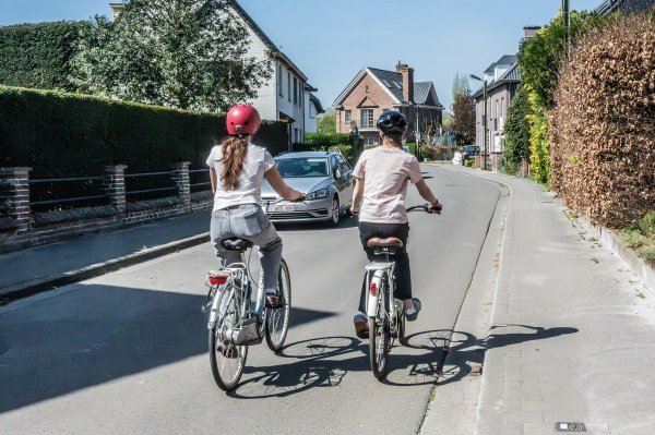 2 fietsers naast elkaar in smalle straat