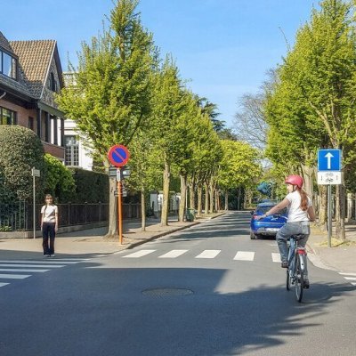 fietser verleent voorrang aan voetganger op zebrapad op een kruispunt