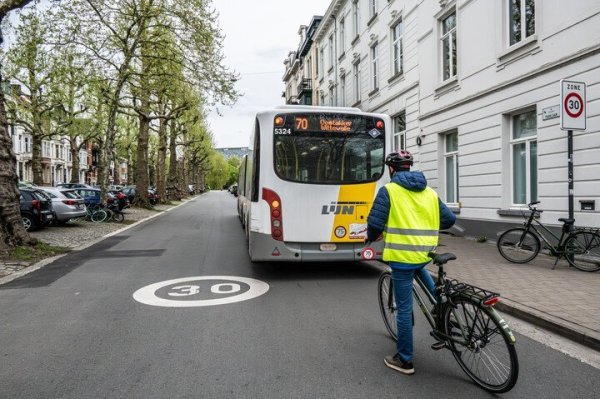 fietser wacht voor bus die halte verlaat