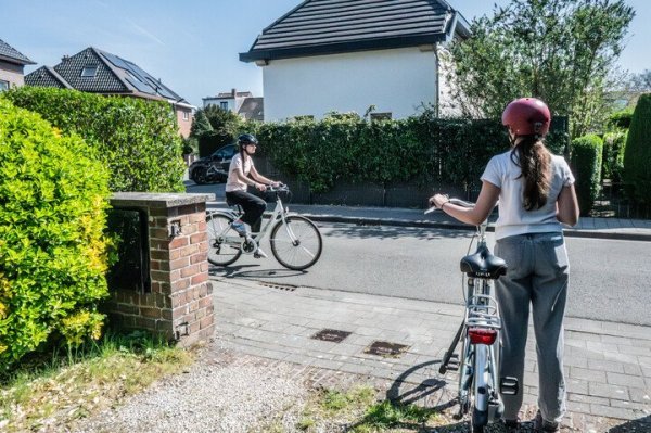 fietser staat klaar om oprit af te rijden, verleent voorrang aan fietser die van links komt